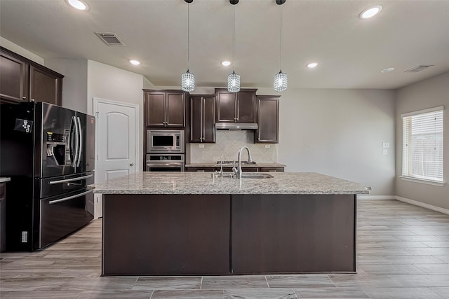 kitchen with a sink, stainless steel appliances, visible vents, and decorative backsplash