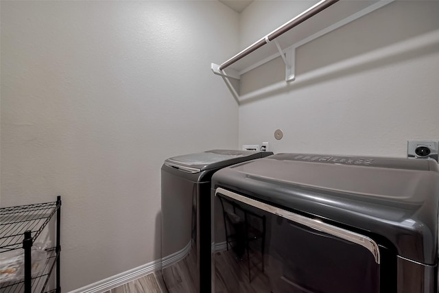 laundry room with washer and dryer, laundry area, wood finished floors, and baseboards