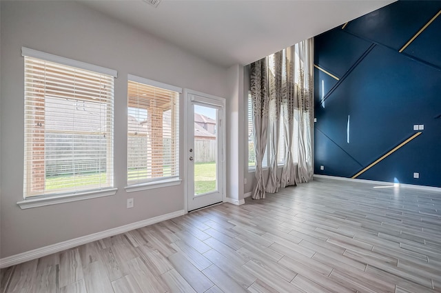 unfurnished room featuring baseboards and wood finished floors