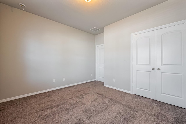 unfurnished bedroom with visible vents, baseboards, carpet, and a closet