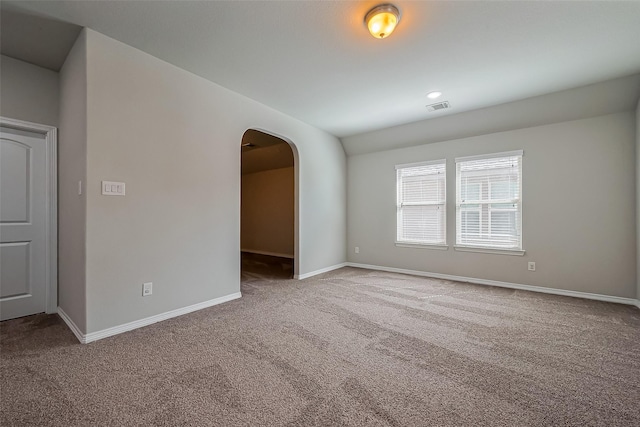 spare room with visible vents, baseboards, arched walkways, and carpet floors