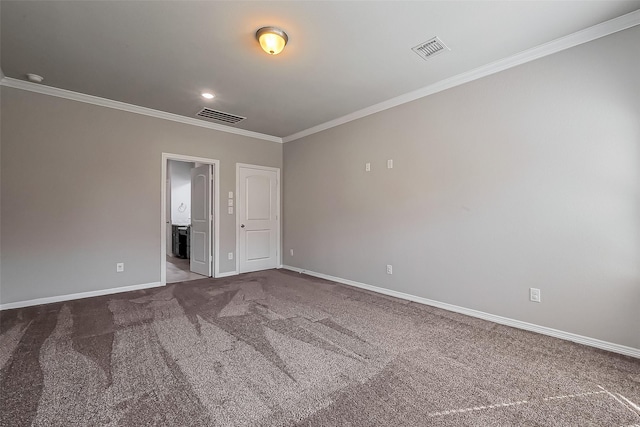 spare room with crown molding, carpet flooring, baseboards, and visible vents