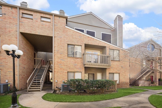 view of property with stairway and central AC unit