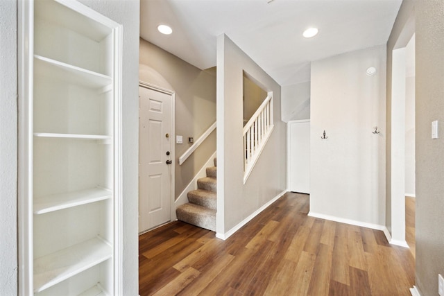 stairway featuring recessed lighting, baseboards, and wood finished floors