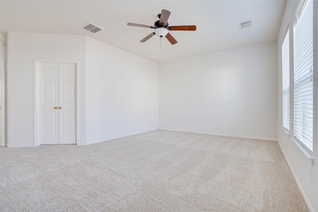 spare room featuring visible vents, a ceiling fan, and carpet