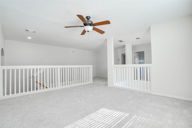 empty room featuring visible vents, carpet, and a ceiling fan