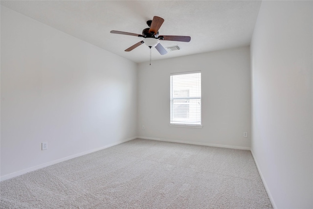 empty room featuring visible vents, baseboards, light colored carpet, and a ceiling fan