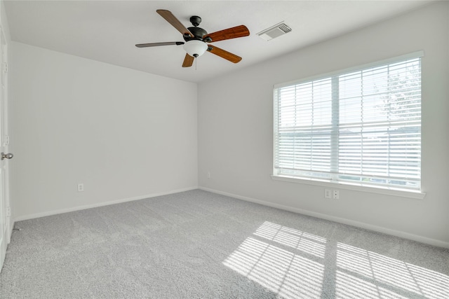 unfurnished room featuring a ceiling fan, visible vents, and a wealth of natural light