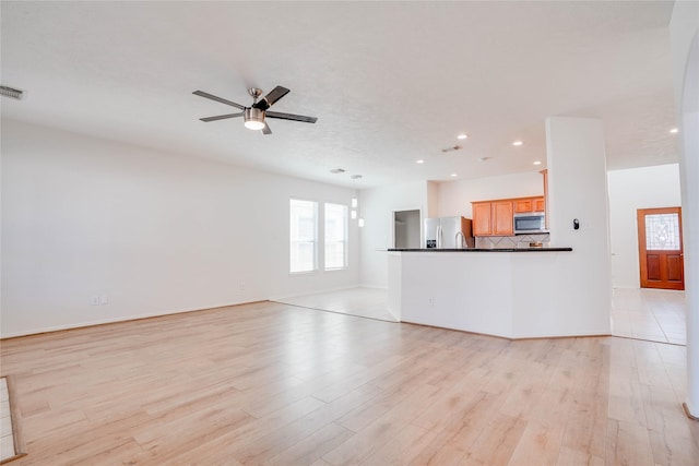 unfurnished living room featuring light wood-type flooring, visible vents, a ceiling fan, recessed lighting, and baseboards