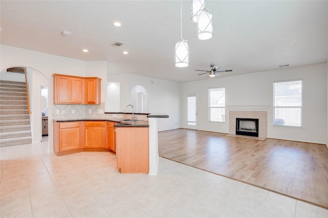 kitchen with visible vents, a healthy amount of sunlight, ceiling fan, decorative backsplash, and a sink