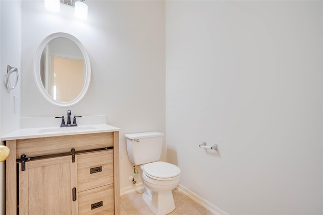 bathroom featuring baseboards, toilet, vanity, and tile patterned flooring