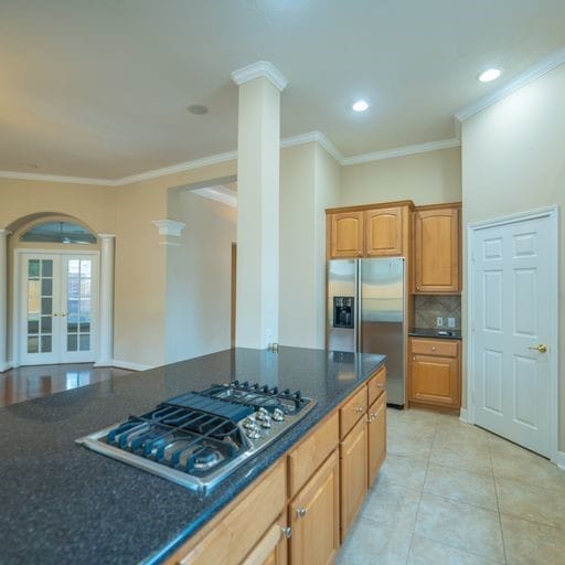 kitchen featuring crown molding, decorative columns, french doors, arched walkways, and stainless steel appliances