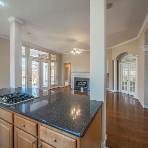 kitchen with a ceiling fan, french doors, crown molding, decorative columns, and stainless steel gas cooktop