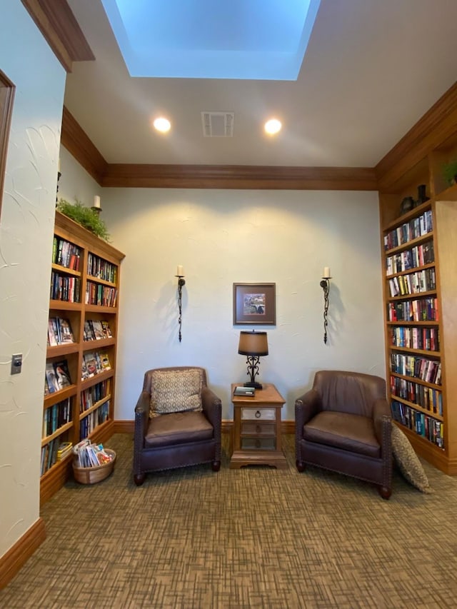 living area with crown molding, bookshelves, carpet, and visible vents