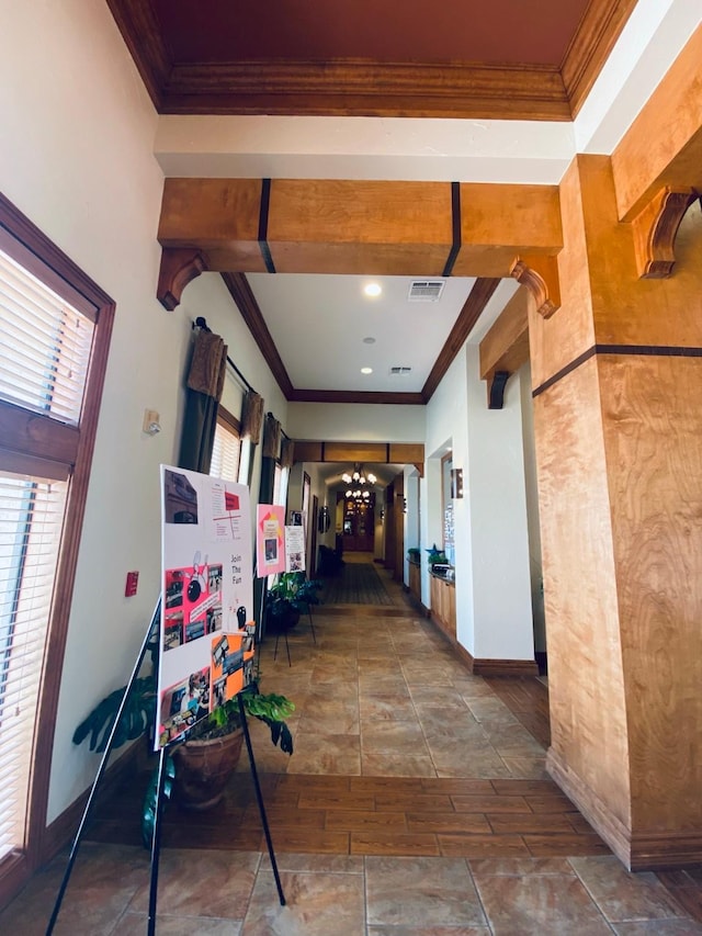 hall featuring plenty of natural light, crown molding, and visible vents