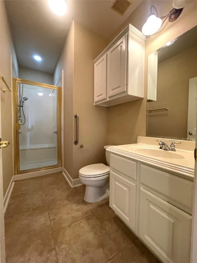 bathroom featuring visible vents, toilet, a stall shower, baseboards, and vanity