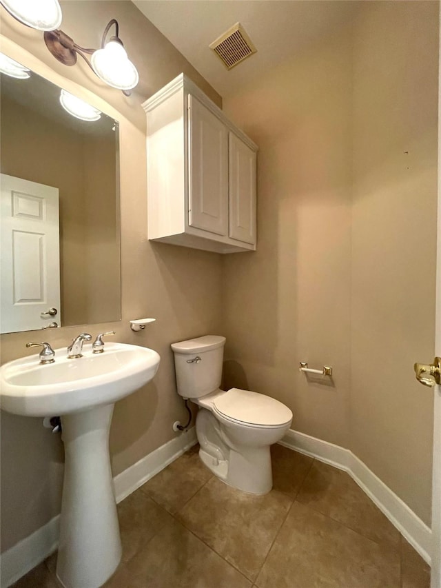 bathroom with tile patterned floors, visible vents, baseboards, and toilet