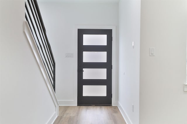 doorway to outside featuring light wood finished floors and baseboards