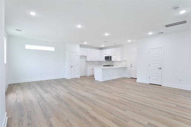 unfurnished living room with visible vents, recessed lighting, light wood-type flooring, and baseboards