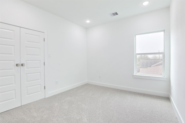 carpeted empty room featuring recessed lighting, baseboards, and visible vents