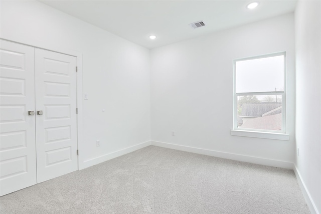 unfurnished room featuring baseboards, visible vents, carpet floors, and recessed lighting