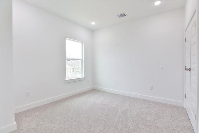 spare room featuring recessed lighting, carpet, visible vents, and baseboards