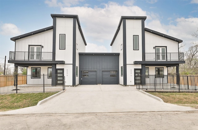 view of front of house with french doors, a fenced front yard, driveway, an attached garage, and a balcony