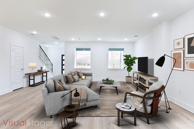 living area with baseboards, visible vents, light wood-type flooring, and recessed lighting