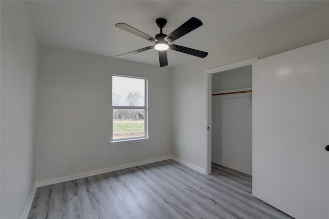 unfurnished bedroom with ceiling fan, a closet, baseboards, and wood finished floors