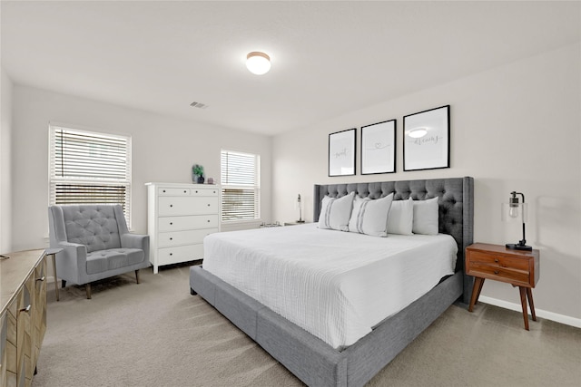 bedroom with light carpet, visible vents, and baseboards