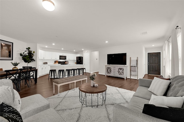 living area with recessed lighting, visible vents, and dark wood-style flooring