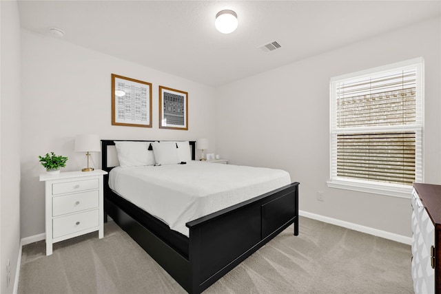 bedroom with visible vents, baseboards, and light carpet