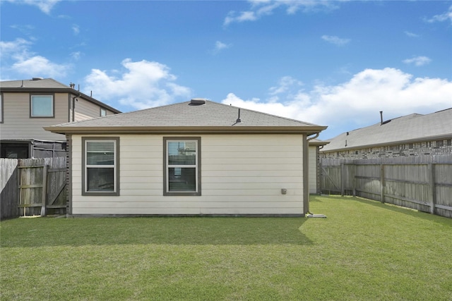 back of property featuring a yard and a fenced backyard