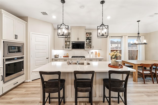 kitchen featuring visible vents, stainless steel appliances, an inviting chandelier, and a sink