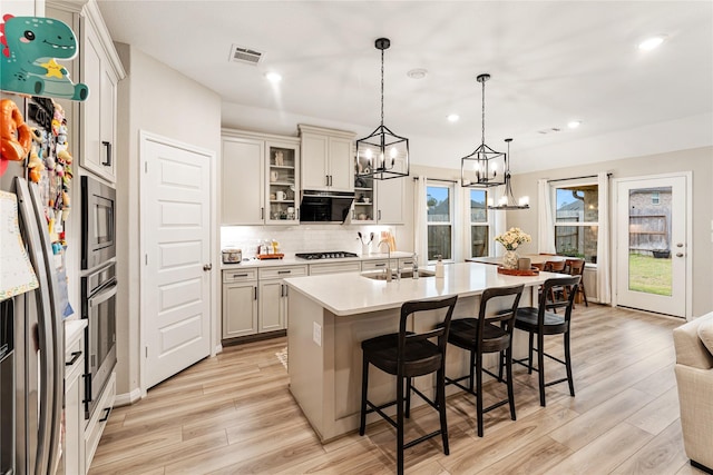 kitchen featuring visible vents, light countertops, appliances with stainless steel finishes, a notable chandelier, and a sink