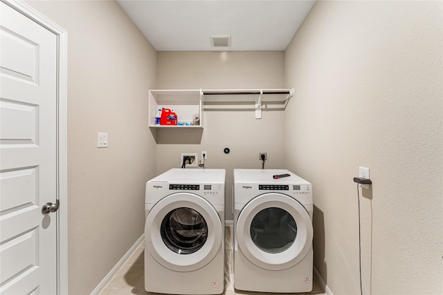 laundry area featuring visible vents, washing machine and dryer, tile patterned flooring, baseboards, and laundry area