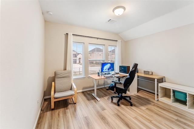 office area with vaulted ceiling, light wood-style flooring, baseboards, and visible vents