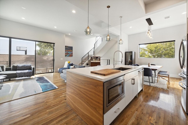 kitchen featuring a healthy amount of sunlight, open floor plan, appliances with stainless steel finishes, and a sink