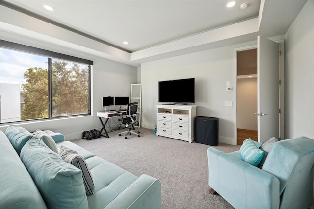 carpeted living area featuring a tray ceiling, recessed lighting, and baseboards