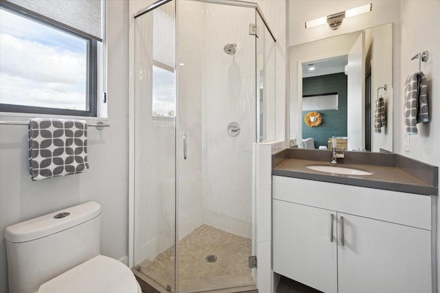 bathroom with vanity, a shower stall, and toilet