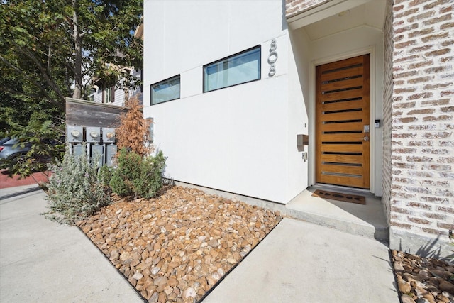 entrance to property with stucco siding and brick siding