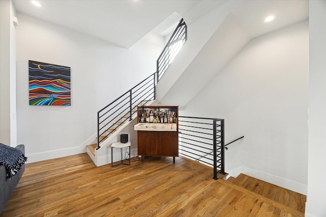 stairs with recessed lighting, baseboards, and wood finished floors