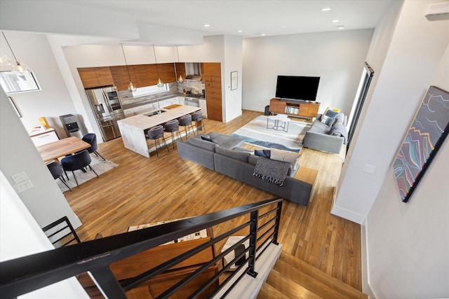 living room with light wood finished floors, recessed lighting, and baseboards