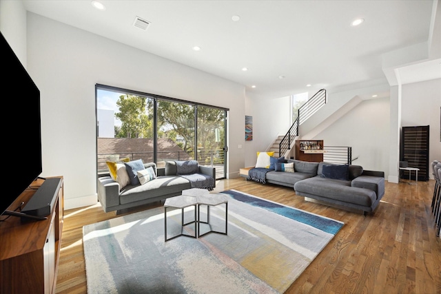 living room with visible vents, baseboards, stairway, recessed lighting, and wood finished floors