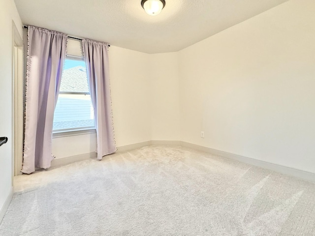 spare room with baseboards, a textured ceiling, and carpet flooring