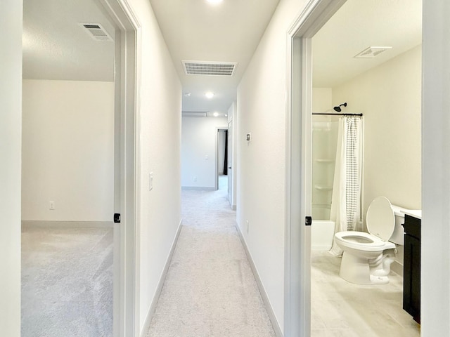 hallway featuring visible vents and carpet floors