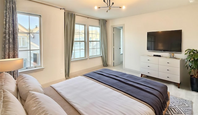 bedroom featuring multiple windows, a notable chandelier, and baseboards