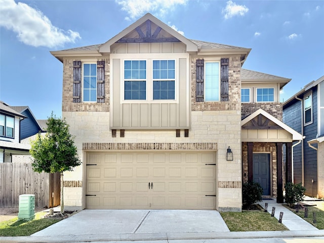 view of front of home featuring stone siding, board and batten siding, driveway, and fence