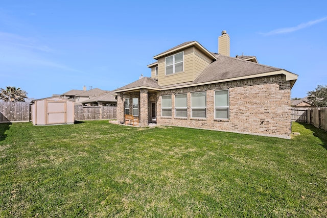 back of property featuring brick siding, a shed, a yard, an outdoor structure, and a fenced backyard