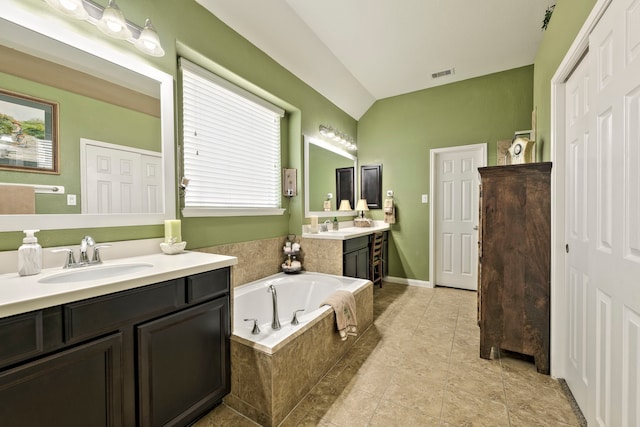 bathroom with tile patterned floors, visible vents, a garden tub, a sink, and lofted ceiling